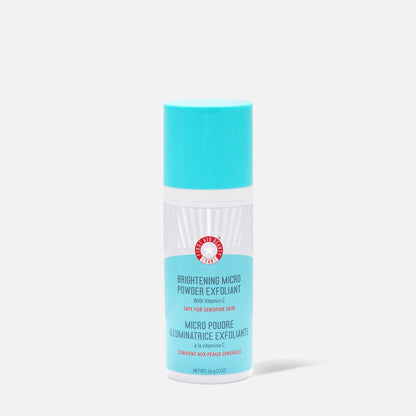 A cylindrical container stands upright, featuring a blue cap and label, reading: "Brightening Micro Powder Exfoliant with Vitamin C. Safe for Sensitive Skin. Net Wt. 56g (2 oz)." Set against a plain background.