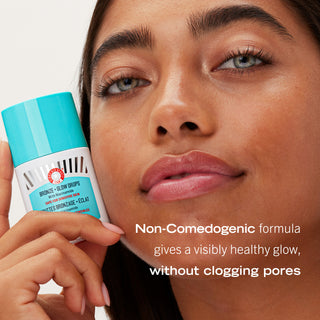Model with bottle of Bronze + Glow Drops. Non-Comedogenic formula gives a visibly healthy glow, without clogging pores.