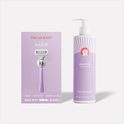 A lavender razor package labeled "First Aid Beauty Rescue Razor" with a bottle of "Smooth Shave Cream" beside it. Text includes "1 Razor - 2 Cartridges - 1 Shower Holder" and "Made with Gillette Blades."