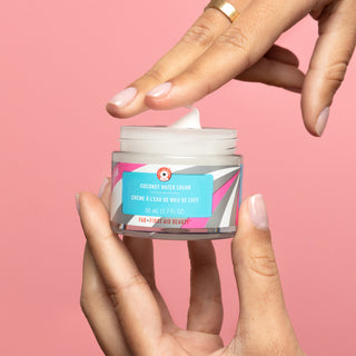 Model holding Coconut Water Cream and showing texture of product.
