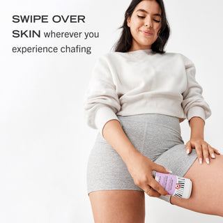A woman using Anti-Chafe Stick on her inner thigh. Swipe over skin where you experience chafing. 