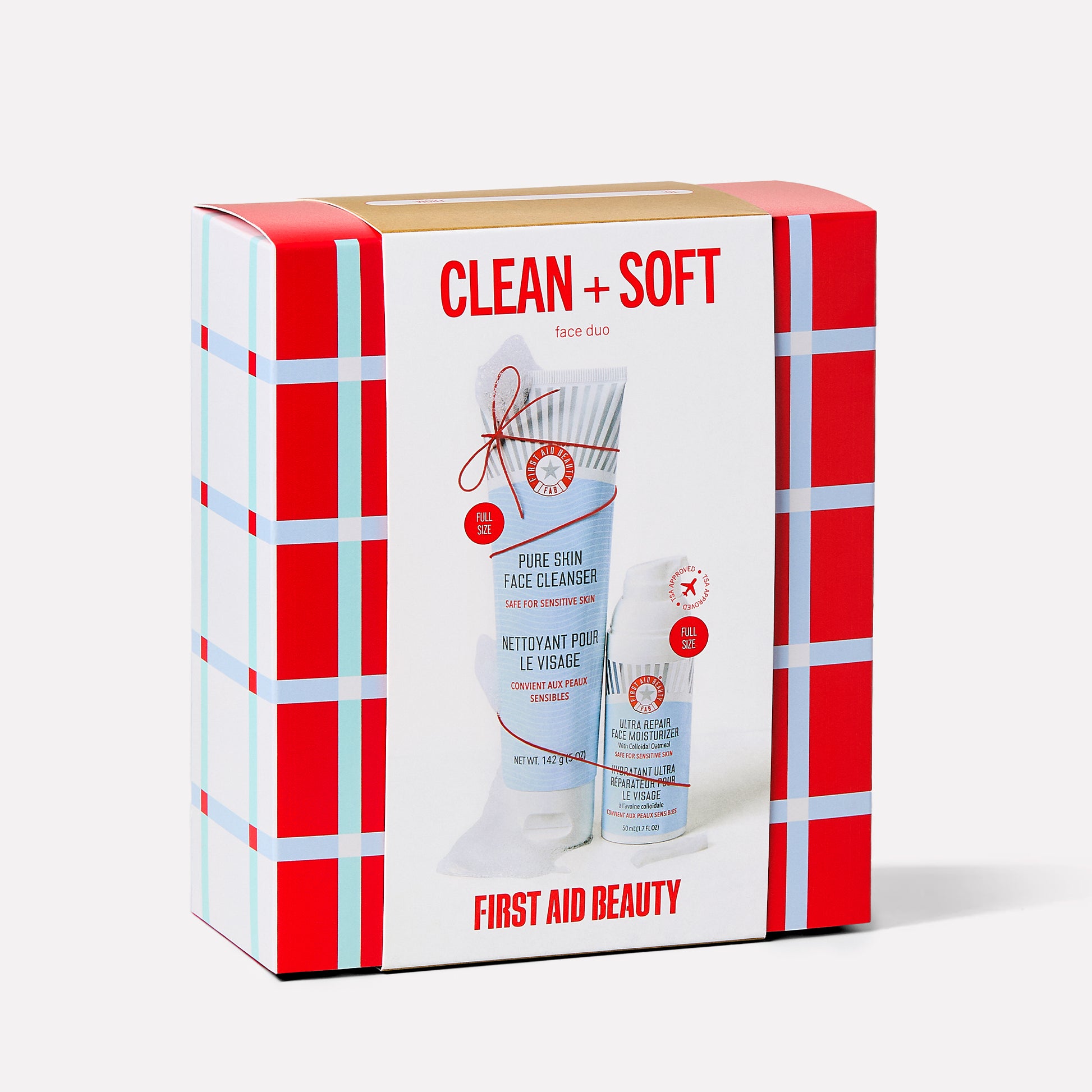 A colorful box displays skincare products. The large print reads "CLEAN + SOFT face duo" and "FIRST AID BEAUTY." The products featured are "PURE SKIN FACE CLEANSER" and "ULTRA REPAIR FACE MOISTURIZER."