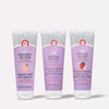 Three tubes labeled "KP Bump Eraser Body Scrub" with 10% AHA, each 226g, stand upright. The tubes feature different scents: Fresh Peach, and Fresh Strawberry. They are safe for sensitive skin.