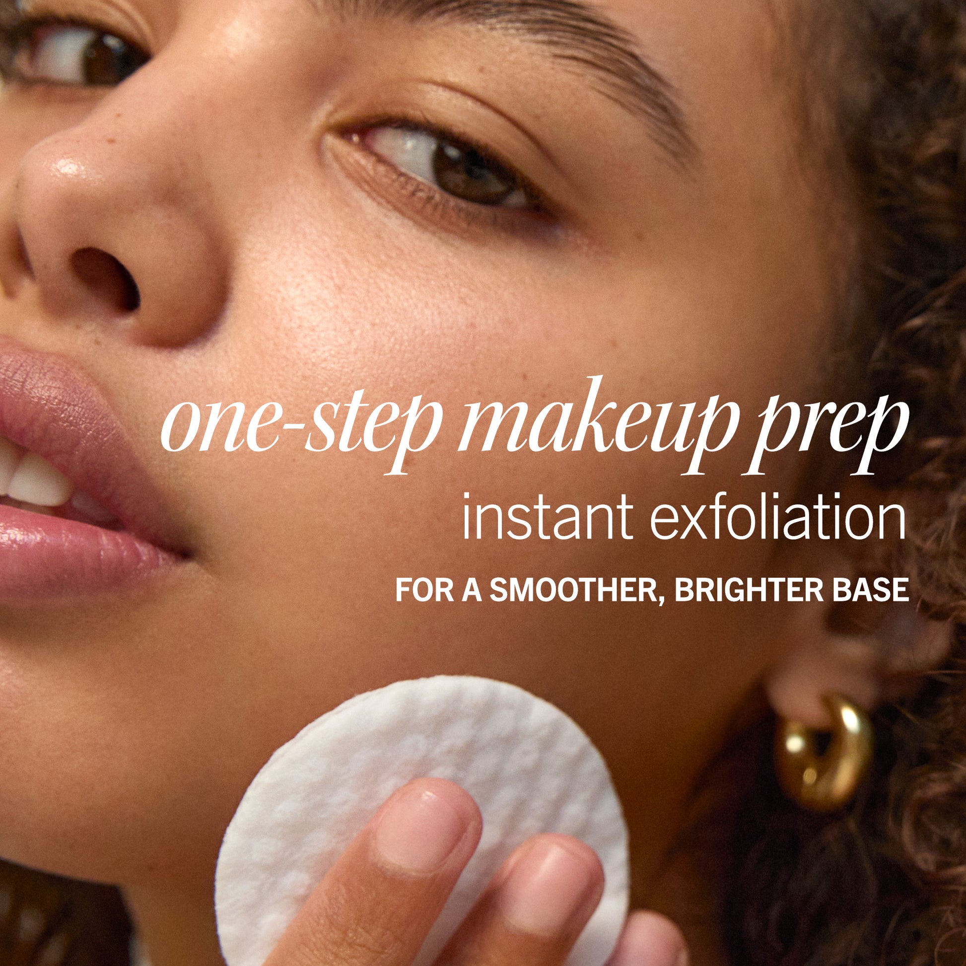 A woman uses a cotton pad on her face, focused on skincare. Text reads: "one-step makeup prep, instant exfoliation, FOR A SMOOTHER, BRIGHTER BASE." The setting is close-up and personal.